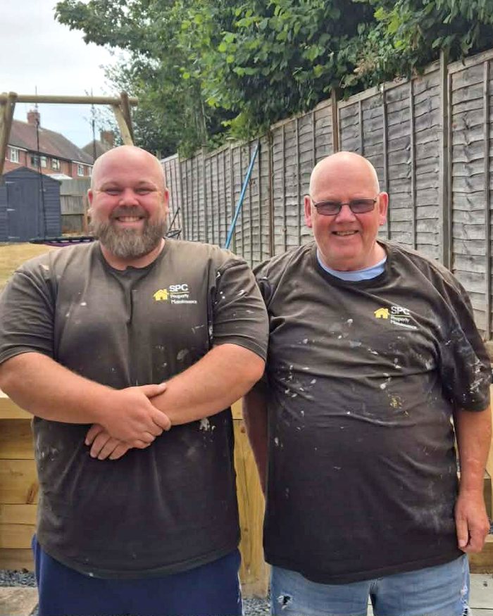 Simon and Tim Charlton of SPC Property Maintenance, stood in a garden in front of raised sleeper beds they have built.